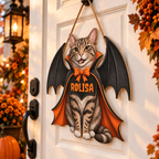 Tabby cat vampire door sign hanging on a white front door decorated with autumn leaves and a pumpkin.