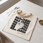 Natural cotton canvas tote bag with black middle finger ring design laid on table