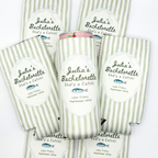 Flat lay of light green custom skinny can cooler sleeves with vertical stripes and 'Julia's Bachelorette' text on white