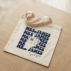 Navy blue custom printed canvas tote bag resting on light wood table