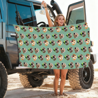 Custom Pet Face Pattern Beach Towel held in front of an off-road vehicle at the beach, featuring a repeating dog face