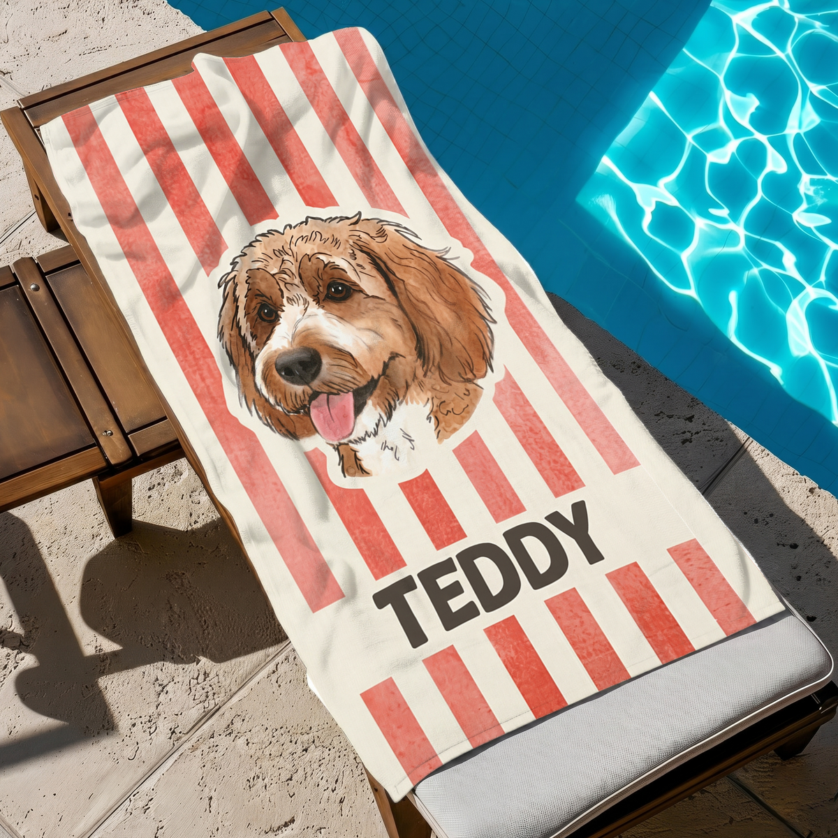 Red striped personalized Doodle dog portrait beach towel resting on a lounge chair beside a sparkling pool.
