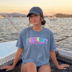 Woman wearing a blue-grey short-sleeve graphic cotton t-shirt and baseball cap with Pregnant Girl Summer print on a boat at