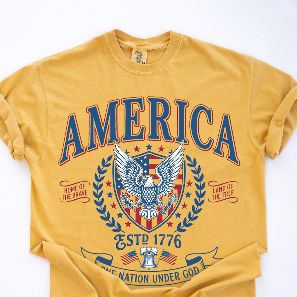 Yellow Comfort Colors t-shirt folded neatly with the vintage America patriotic eagle graphic tee print visible