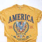 Yellow Comfort Colors t-shirt folded neatly with the vintage America patriotic eagle graphic tee print visible
