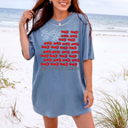 Woman wearing a blue cotton graphic t-shirt on a sandy beach near the ocean