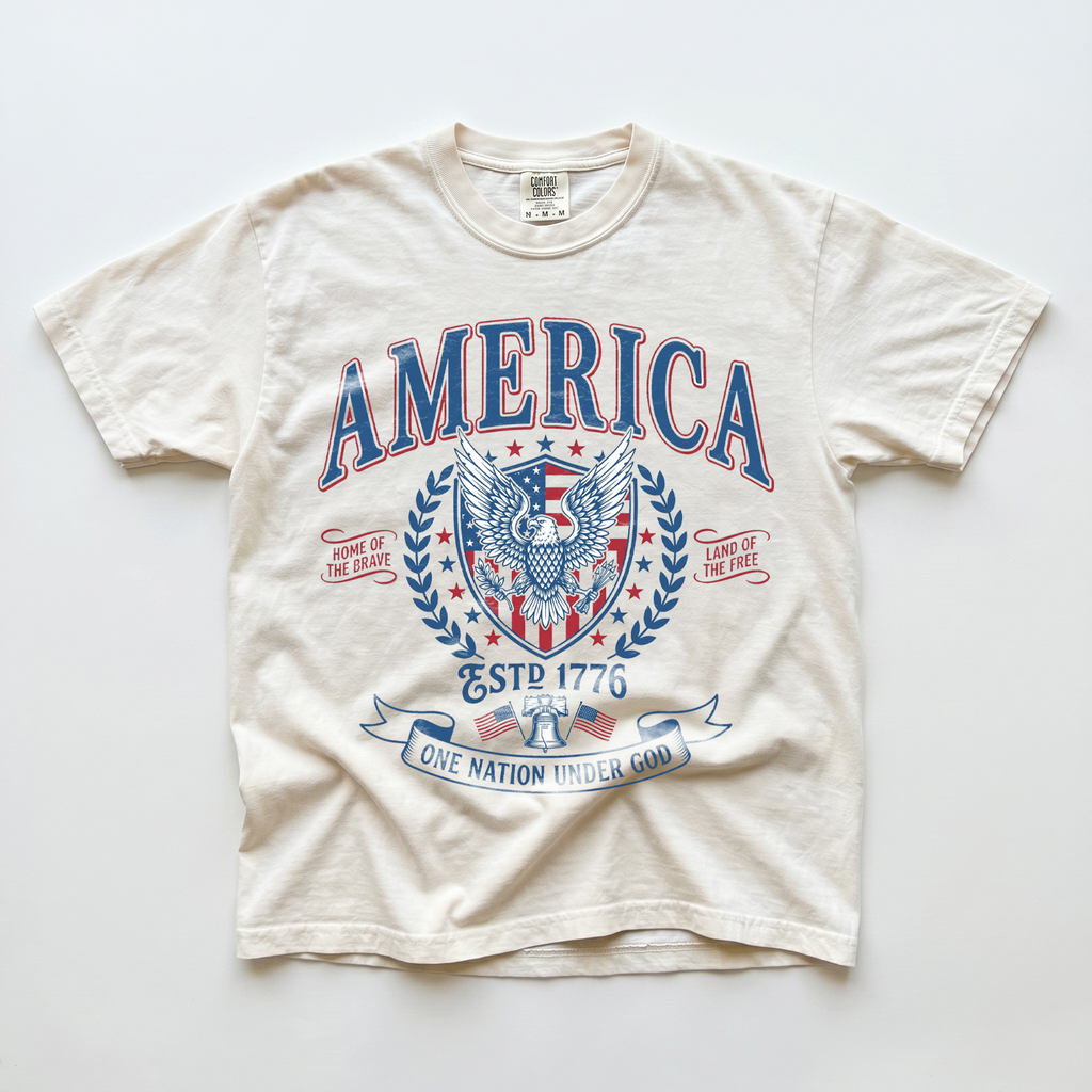 Ivory garment-dyed t-shirt laid flat showing the vintage America patriotic eagle graphic tee print