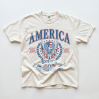 Ivory garment-dyed t-shirt laid flat showing the vintage America patriotic eagle graphic tee print