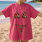 Vintage coral pink t-shirt featuring leopard bikini graphic and red kiss marks by the sea.