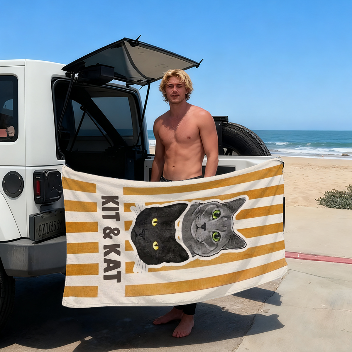 Shirtless man holding a yellow and white striped pet portrait beach towel featuring a black and grey cat and the text KIT &
