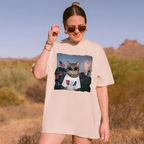 Woman wearing cream Funny American Cat Graphic Tee outside with desert and mountain landscape in background.