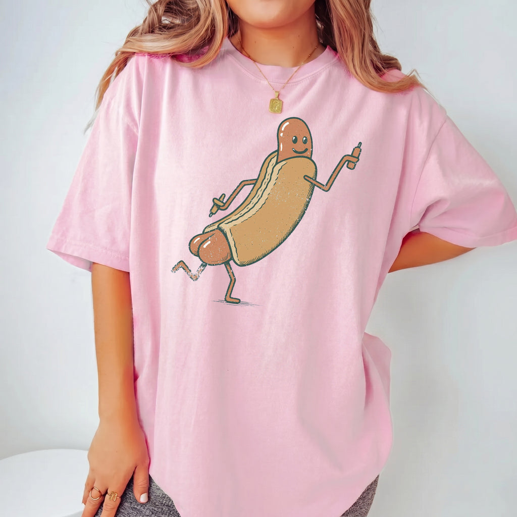 Woman wearing pastel pink Funny Hotdog Graphic T-Shirt showcasing retro cartoon wiener design with funny gag gift appeal.