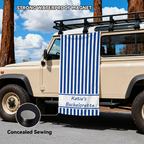 A blue and white custom name striped beach towel hanging on an off-road vehicle door.