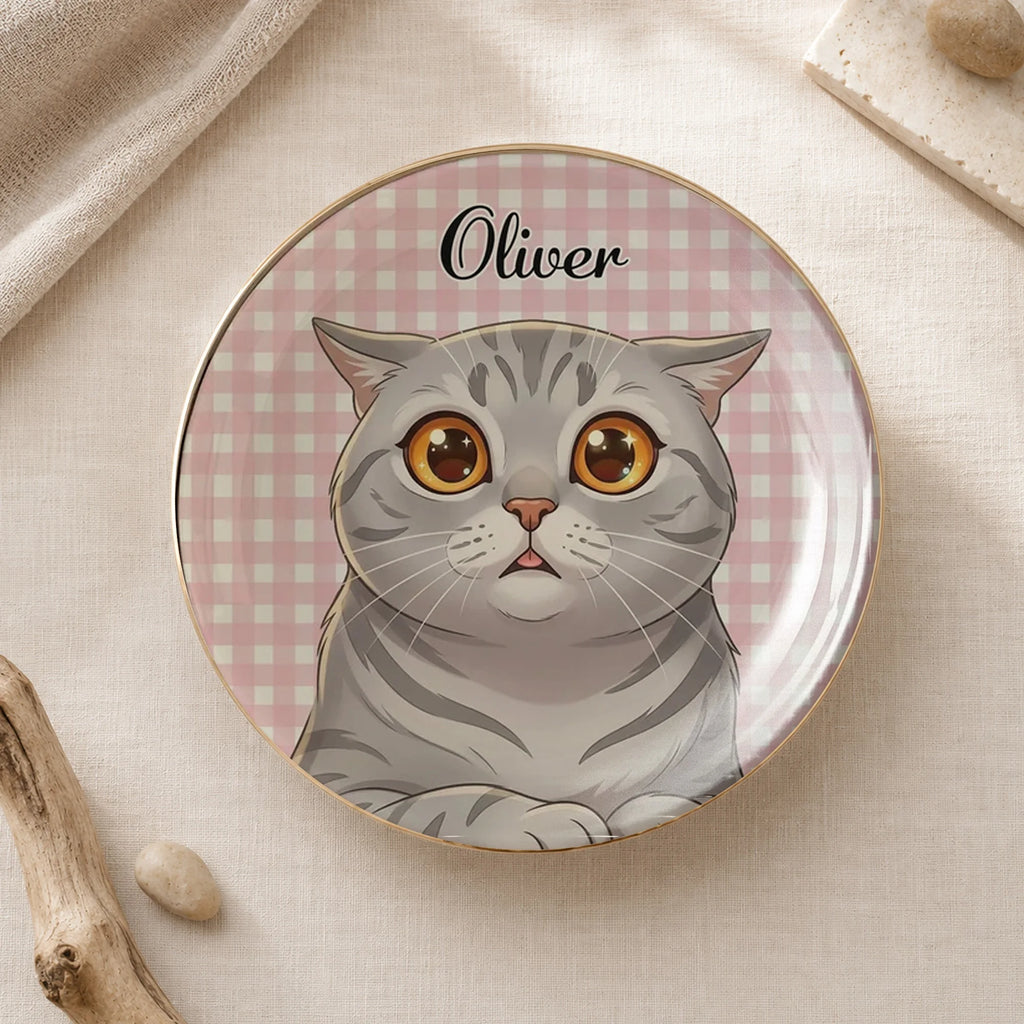 Round ceramic cat ring dish with custom name Oliver on a pink gingham background, displayed on neutral fabric.