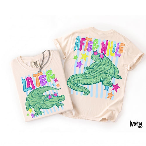 Ivory t-shirt featuring green alligator graphic with star sunglasses, Later and After While text, and stars on a white