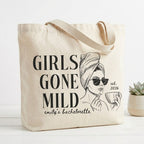 Beige canvas bridal shower gift bag displaying black Girls Gone Mild graphic print with hair towel illustration and year.