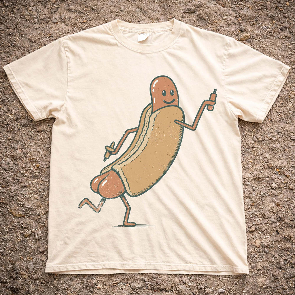 Cream colored Funny Hotdog Graphic T-Shirt laid flat on textured ground showing vintage illustrated running hotdog design.