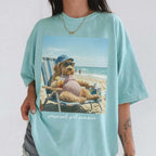 Light turquoise casual summer beach vacation top with a graphic of a lounging pregnant goldendoodle wearing sunglasses.