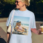 Light blue pastel pregnancy graphic tee showcasing a funny sunbathing goldendoodle wearing a cap and swimsuit.