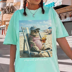 Woman wearing a light mint green t-shirt with the funny cat meme graphic against an urban sidewalk backdrop.