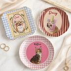 Three ceramic trinket dishes with custom pet portraits and names displayed on a white marble surface with rings.