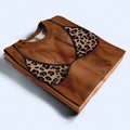 Folded Custom Bikini Body Shirt featuring a realistic leopard print bikini and tanned skin illusion graphic print.