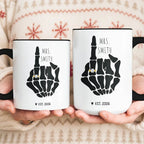 Two white mugs with black interiors held in hands, displaying skeleton hand with a gold ring and Mrs. Smith text.