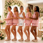 Five bridesmaids modeling pink and white custom bridal pjs with embroidered names on the ruffle shorts.