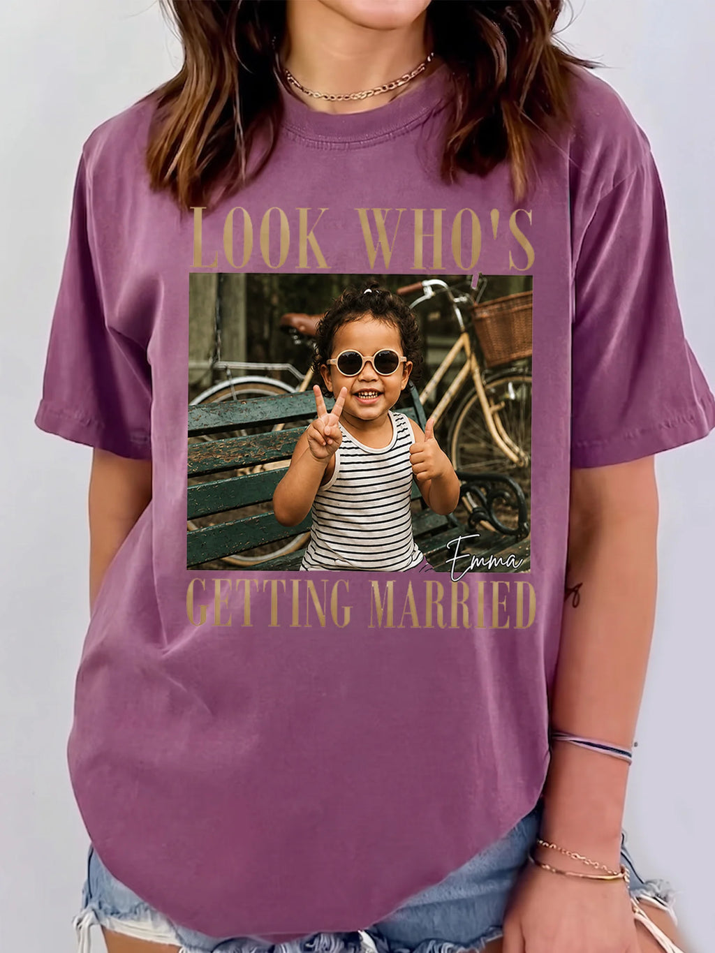A person wearing a purple custom photo t-shirt featuring a childhood picture and customized name graphic.