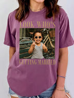 A person wearing a purple custom photo t-shirt featuring a childhood picture and customized name graphic.