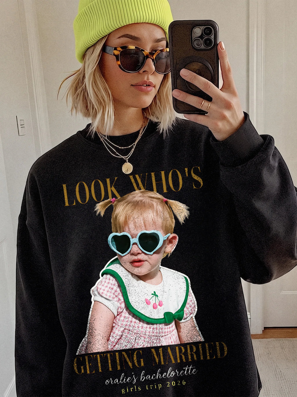 Personalized bachelorette t-shirt in black worn by a woman wearing sunglasses and a bright yellow beanie.