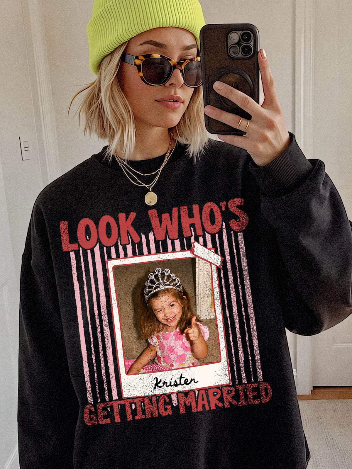 Woman wearing black custom photo shirt with neon beanie and sunglasses, displaying retro polaroid wedding graphic.