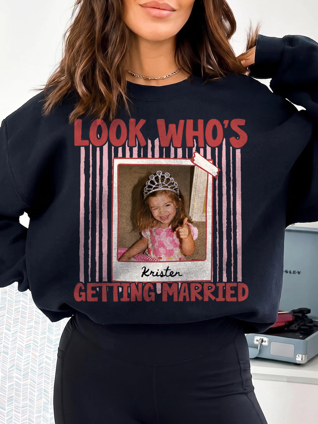 Woman in dark grey custom name shirt featuring childhood memory polaroid frame and red vertical stripe design.