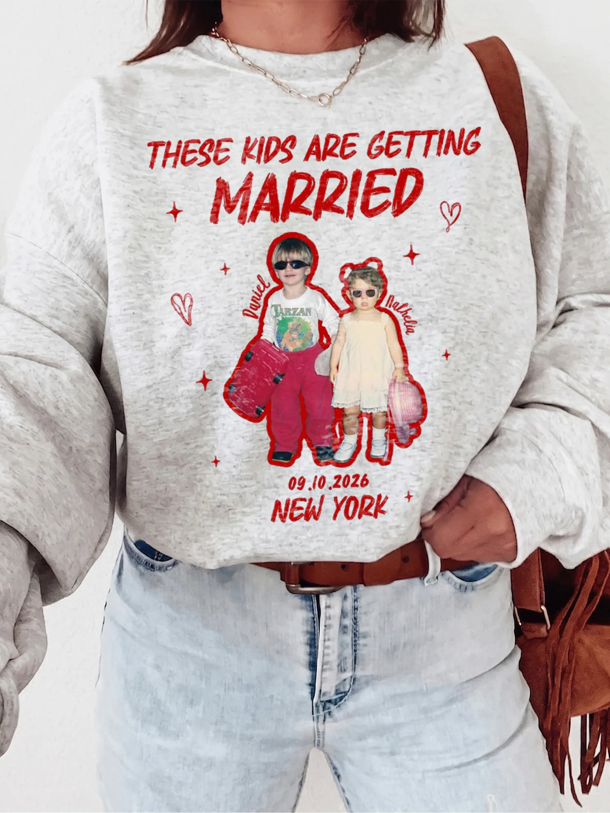 Woman wearing grey speckled custom photo sweatshirt featuring childhood photos, red names, date, and New York location.