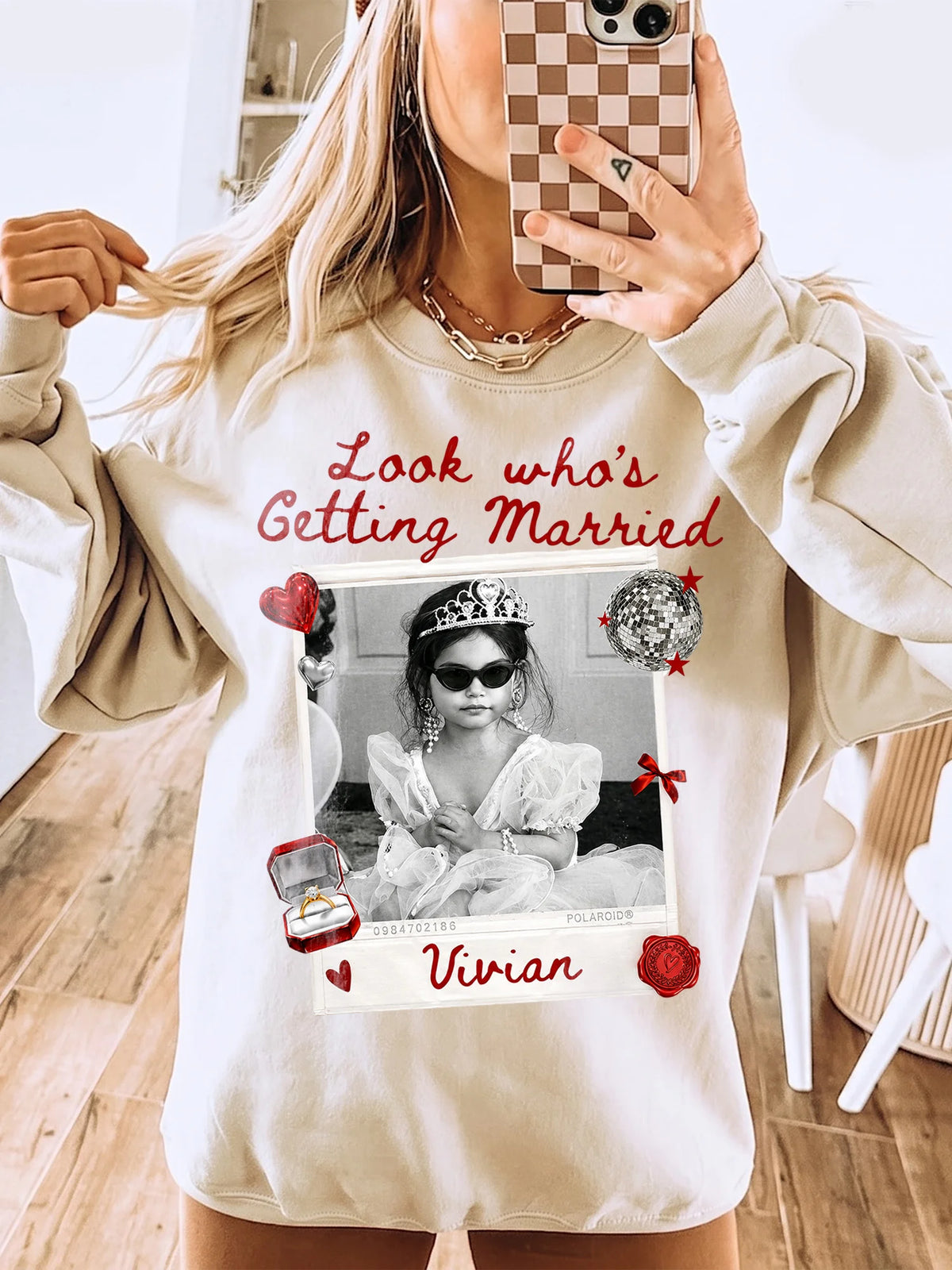 Sand-colored crewneck sweatshirt featuring a retro polaroid graphic with red text and custom name.